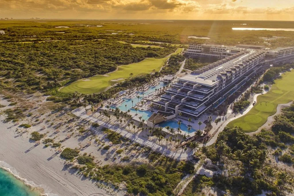 Aerial sunset view of beachfront resort pools, tropical grounds and golf course, Atelier Playa Mujeres, Cancun
