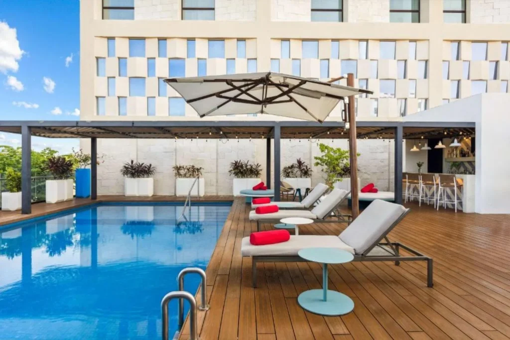 Rooftop pool with sun loungers at Avani Cancun Airport in Cancún, Mexico.