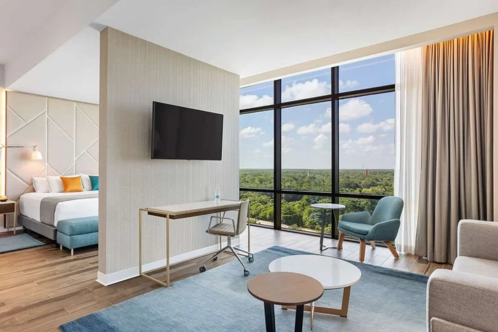 Modern suite at Avani Cancun Airport Hotel in Cancún, featuring a spacious living area, workspace, and panoramic city views.