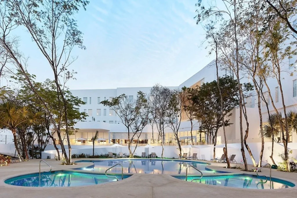 Outdoor pool surrounded by trees at Fairfield by Marriott Inn & Suites Cancun Airport in Cancun, Mexico