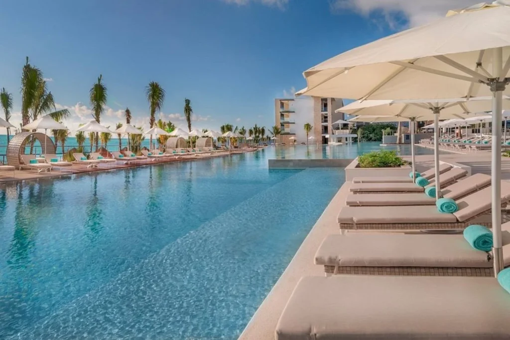 Oceanfront infinity pool with luxury cabanas and sun loungers at Haven Riviera Cancun in Cancún, Mexico.