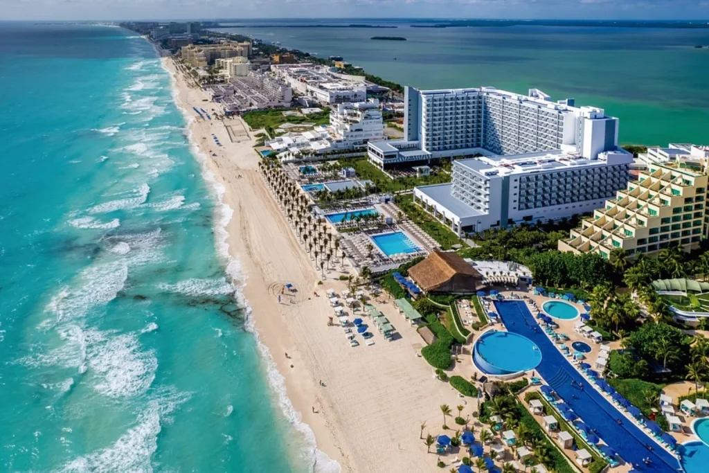 Beachfront resort with multiple swimming pools, a long sandy beach and turquoise Caribbean waters at Hotel Riu Palace Kukulkan in Cancun.