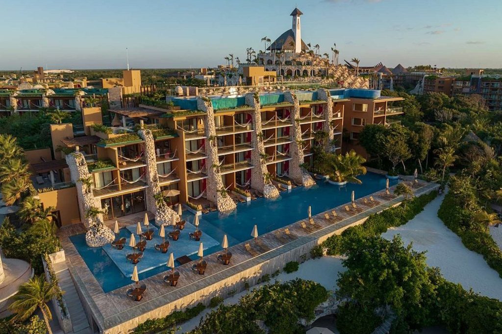 Aerial view showcasing the resort, infinity pools, and lush tropical surroundings at Hotel Xcaret México in Playa del Carmen, Riviera Maya, Mexico