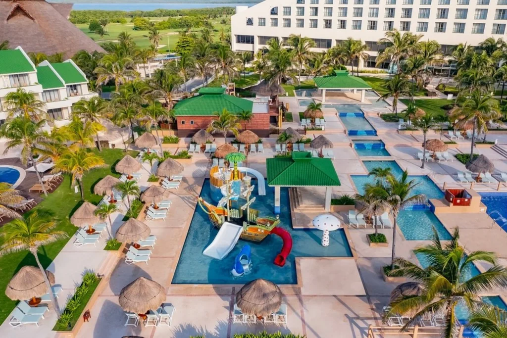 Family-friendly pool complex with colorful water slides, sun loungers and tropical palms, Iberostar Selection Cancún, Cancun