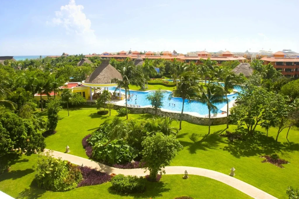 Large outdoor pool surrounded by palm trees and tropical gardens, Iberostar Waves Paraiso Beach, Riviera Maya