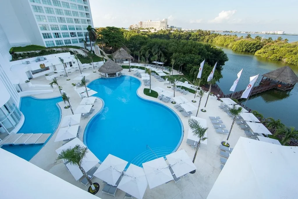 Outdoor swimming pool and lagoon view at Le Blanc Spa Resort Cancun