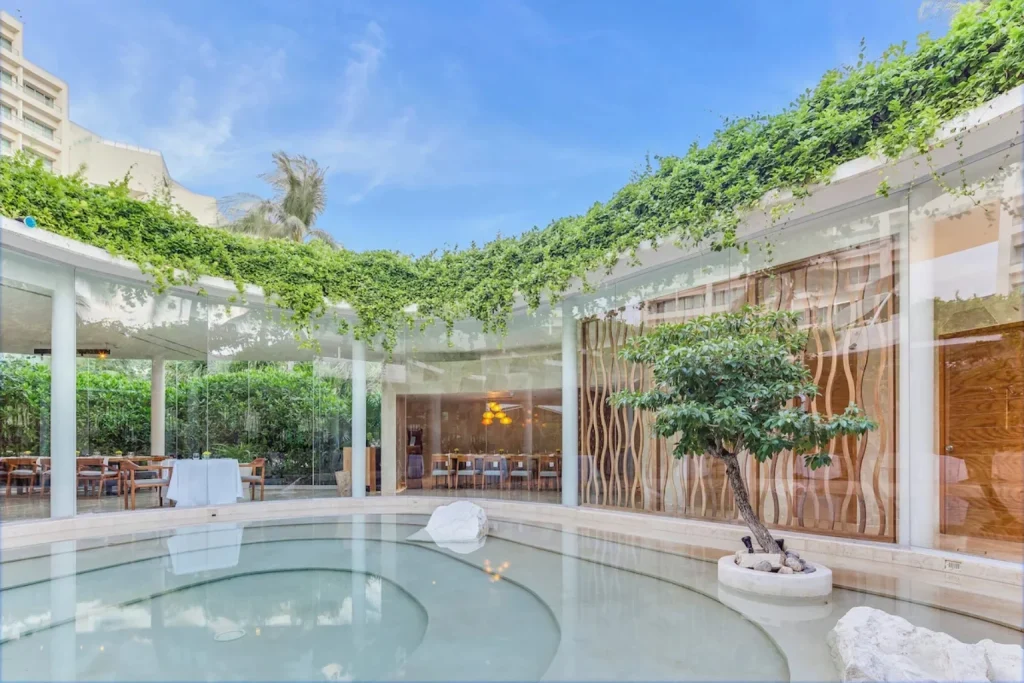 Indoor water garden with greenery and glass walls at Live Aqua Beach Resort Cancun