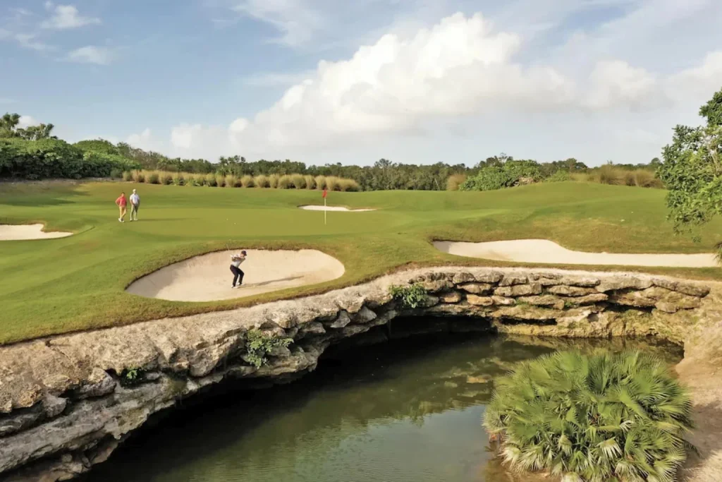 Lush golf course with sand bunkers set around a natural limestone water feature, Moon Palace Nizuc, Cancun