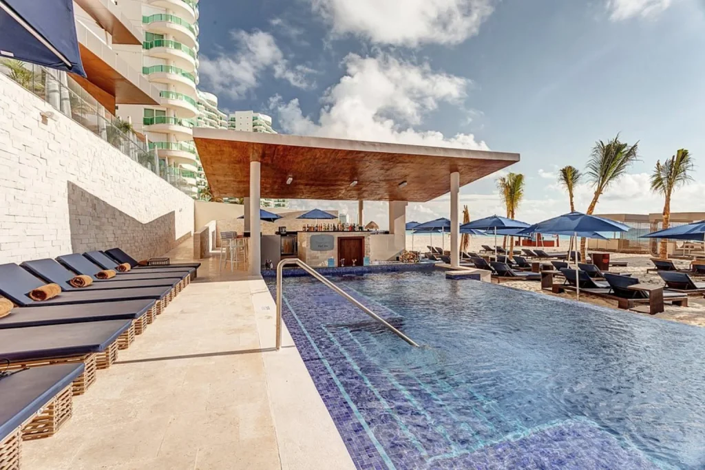 Outdoor pool with sun loungers and poolside bar, Royalton CHIC Cancun, Cancun