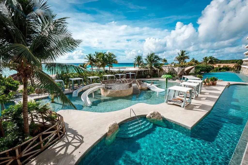Family pool with slides and cabanas at Palmaïa – The House of AïA in Playa del Carmen, Riviera Maya, Mexico.