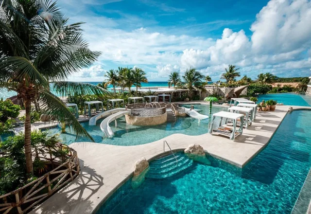 Family pool with slides and cabanas at Palmaïa – The House of AïA in Playa del Carmen, Riviera Maya, Mexico.