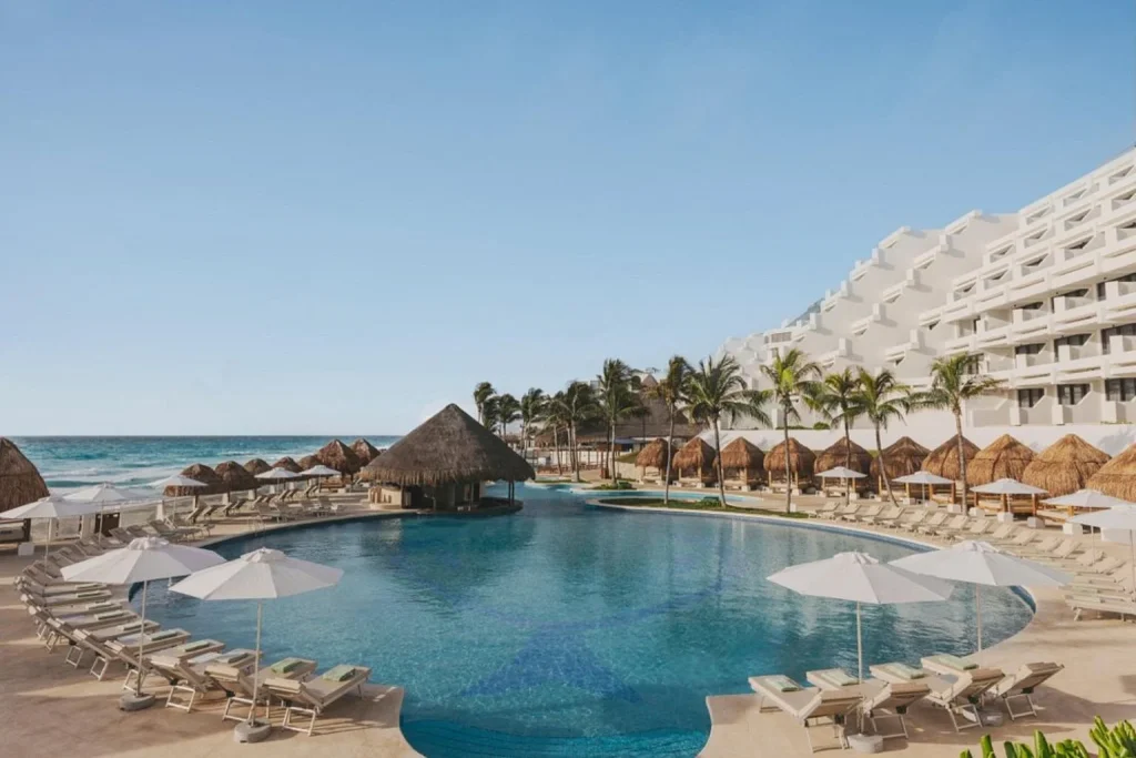 Oceanfront swimming pool with sun loungers at Paradisus Cancun in Cancún.
