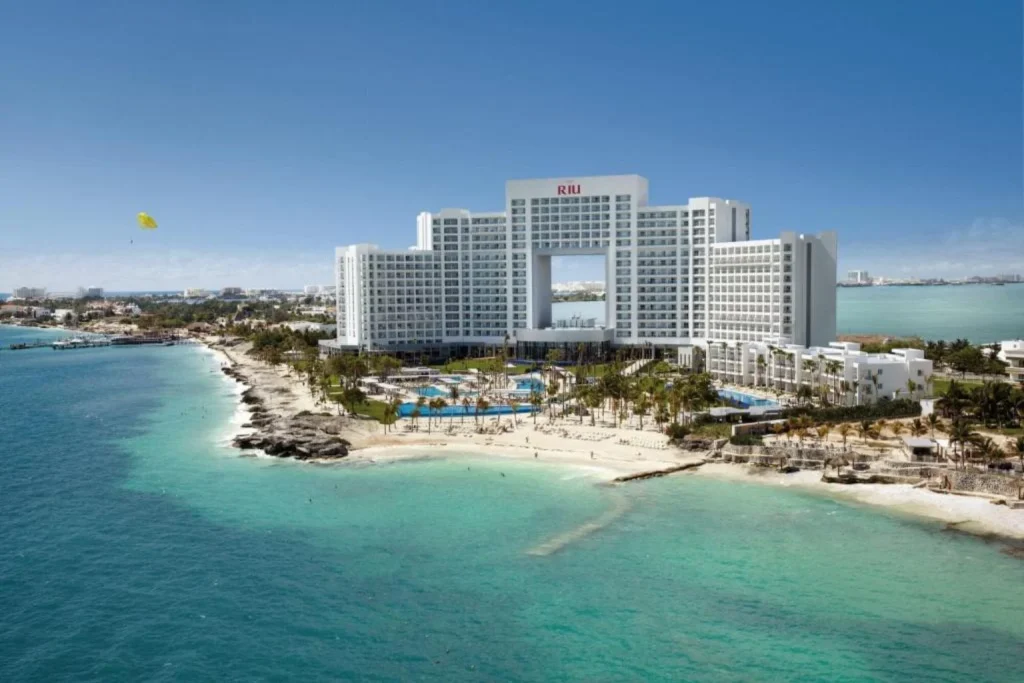 Aerial view of the beachfront resort, swimming pools, and Caribbean Sea at Riu Palace Peninsula in Cancún, Mexico.