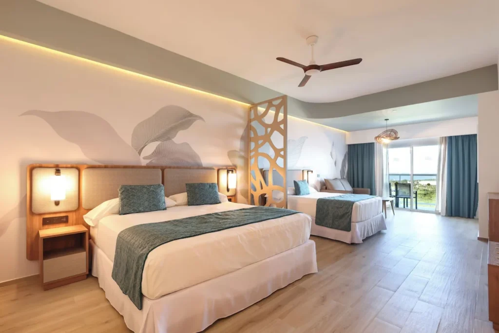 Family room with two beds and sitting area at Riu Ventura Cancun
