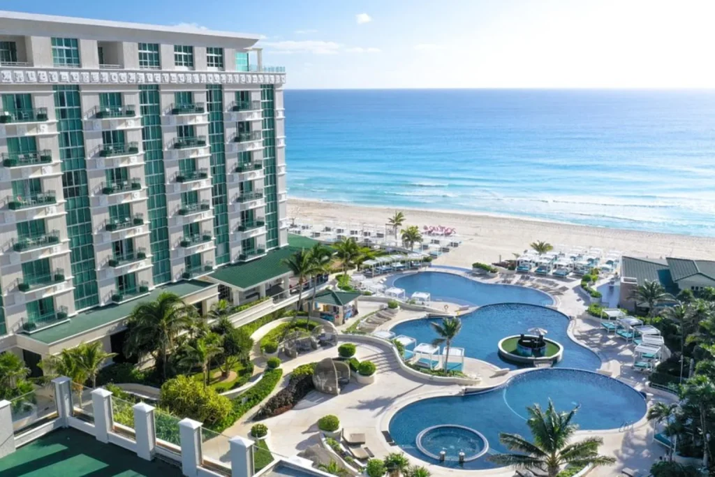 Outdoor swimming pool and resort buildings at Sandos Cancun