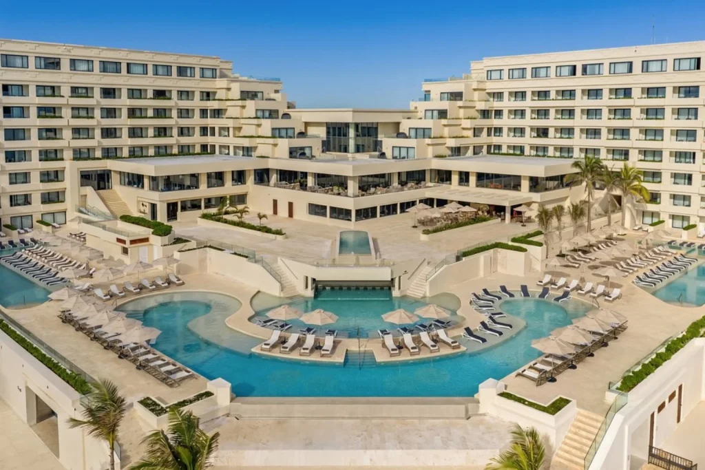 Large swimming pool complex and hotel exterior at Secrets Mirabel Cancun