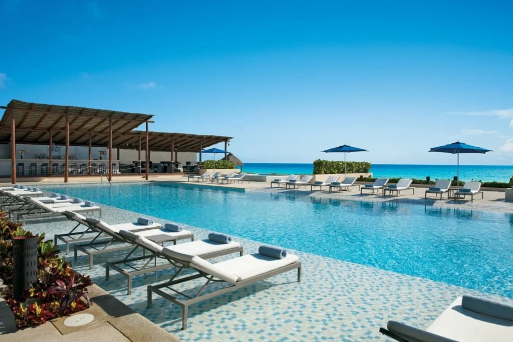 Infinity pool with sun loungers overlooking the ocean at Secrets The Vine Cancun