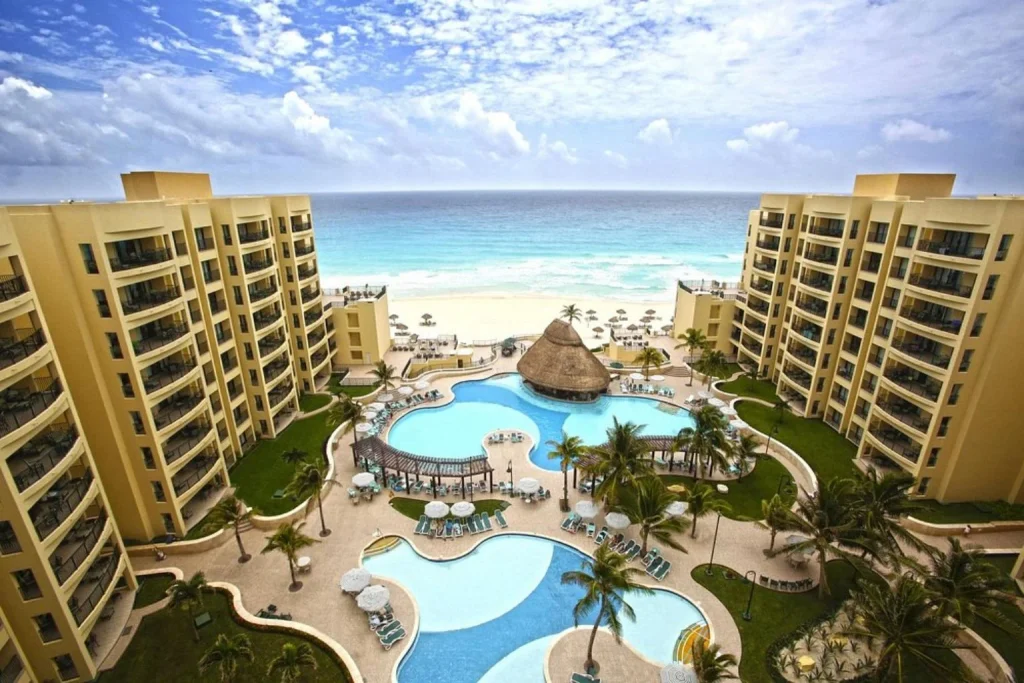 Aerial view of the oceanfront swimming pools and beachfront at The Royal Sands All Suites Resort & Spa Cancun in Cancún, Mexico.